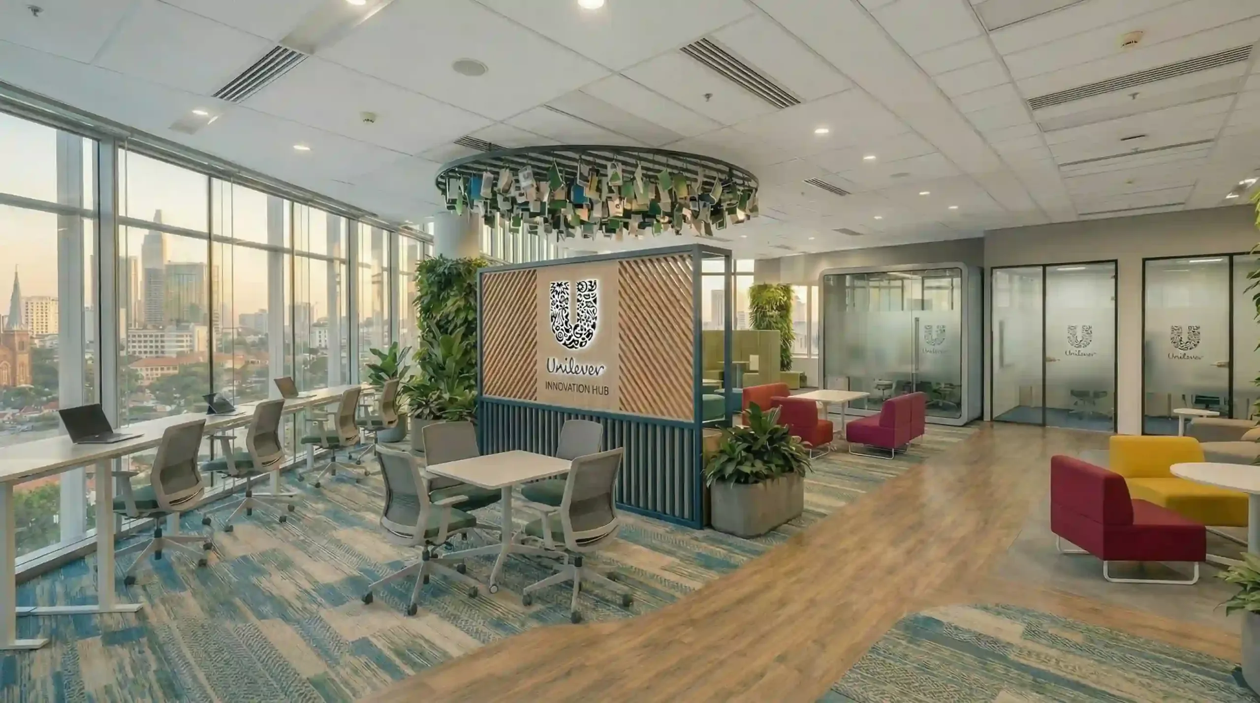 Tổng quan dự án thiết kế thi công văn phòng Unilever mở rộng, nổi bật vách ngăn gỗ trung tâm và khu vực sofa màu vàng đỏ.